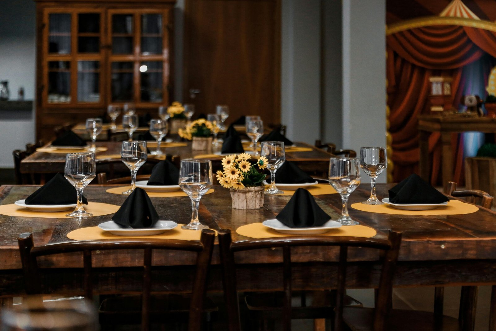 A beautifully arranged dining table with elegant glassware and floral centerpieces set for a special occasion.
